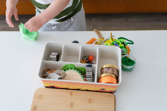A pair of kids playing in a kitchen with their sensory kit