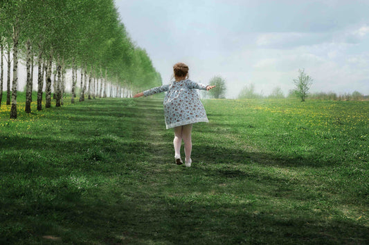 Little girl running through green landscape