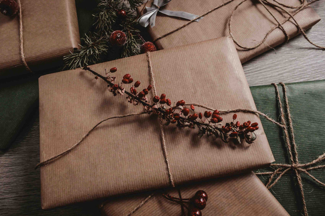 Christmas presents wrapped in brown wrapping paper with red holly