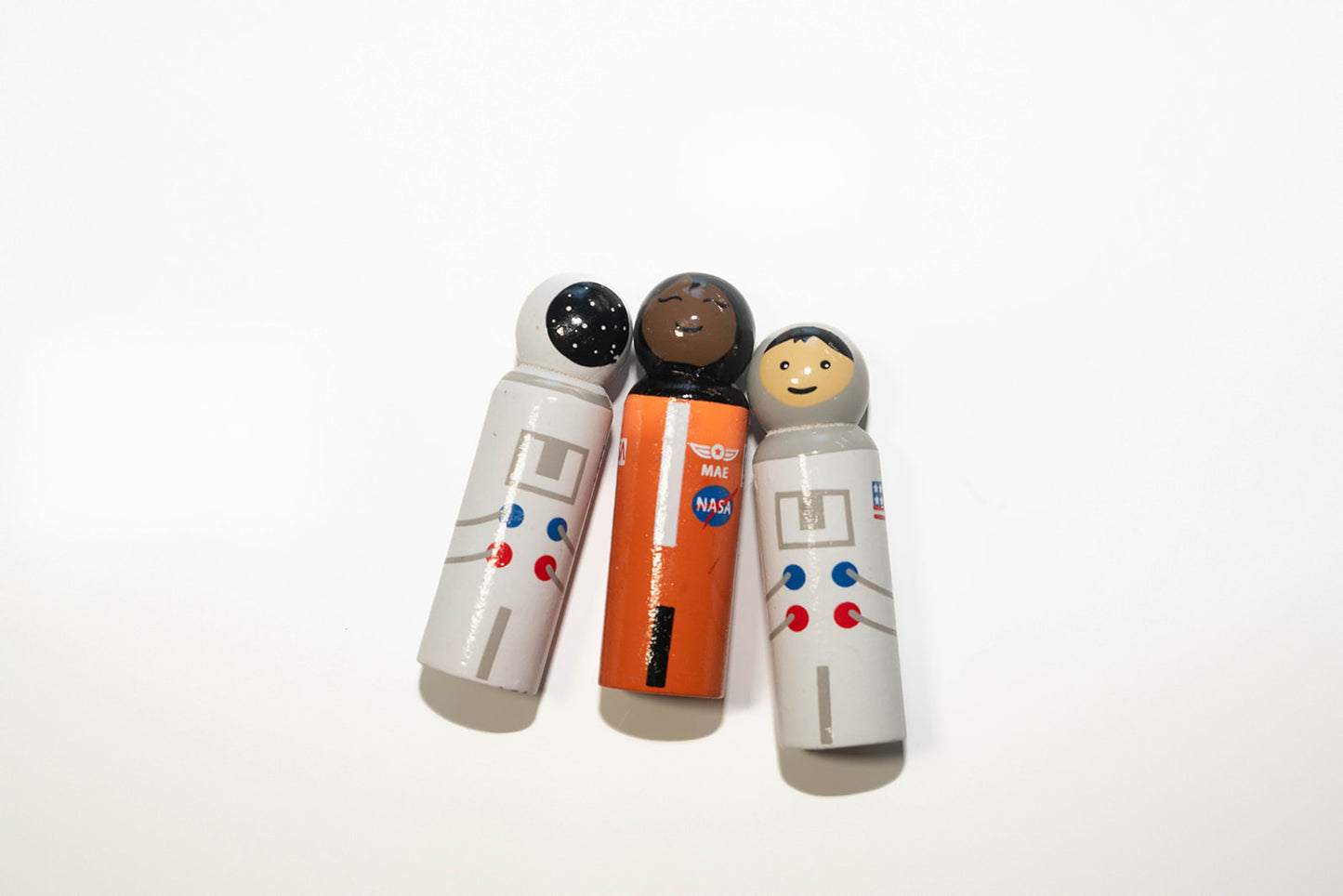 Hand painted wooden astronaut dolls. Dressed in whit outer space outfits with helmet and star reflection and cute face. Mae Jemison dressed in orange NASA inspired outfit.