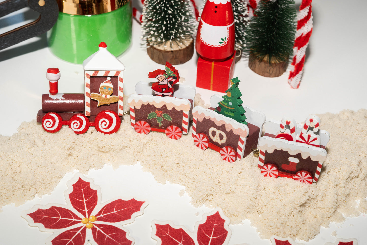 Wooden Christmas train with engine and 3 additional cars with a Santa, tree and peppermint treats in each. Gingerbread man driving the train.