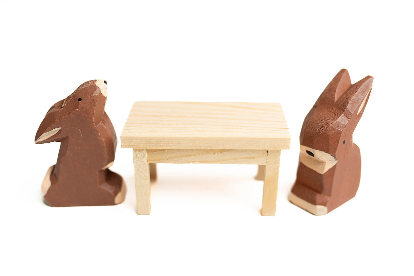 2 chocolate bunnies sitting at mini picnic table