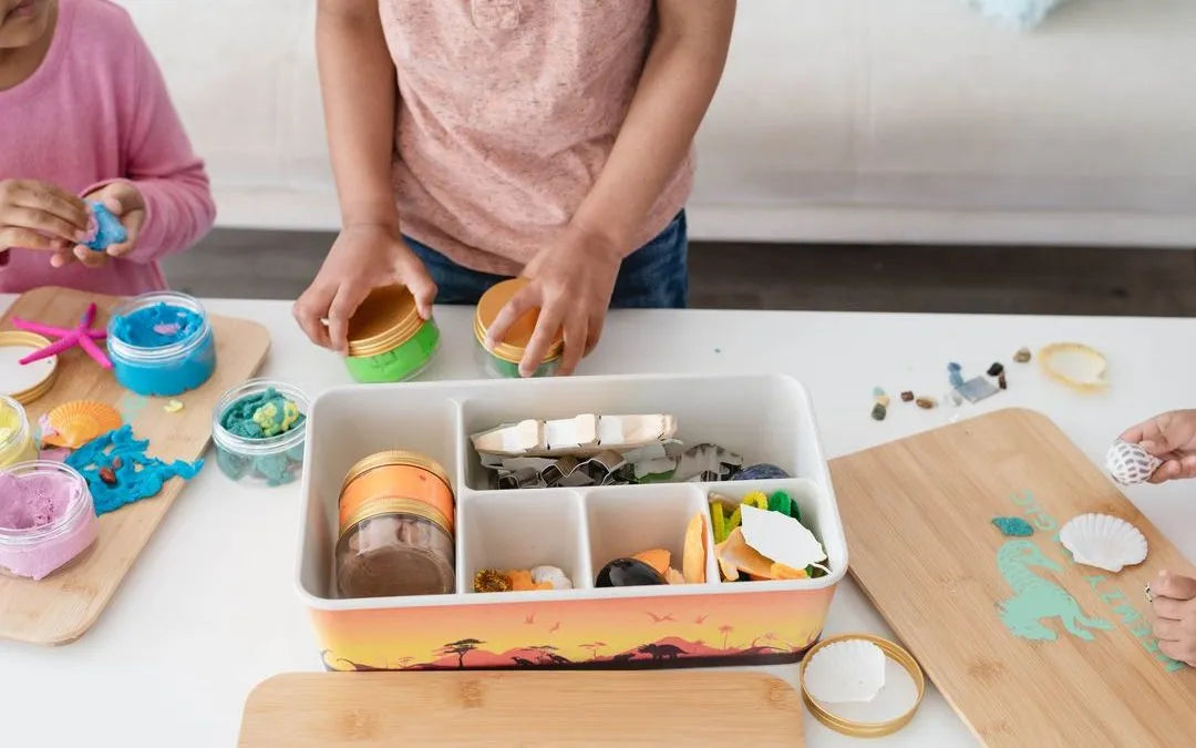 children playing with play dough, stones, and sea shells from meemzy magics sensory toy kits