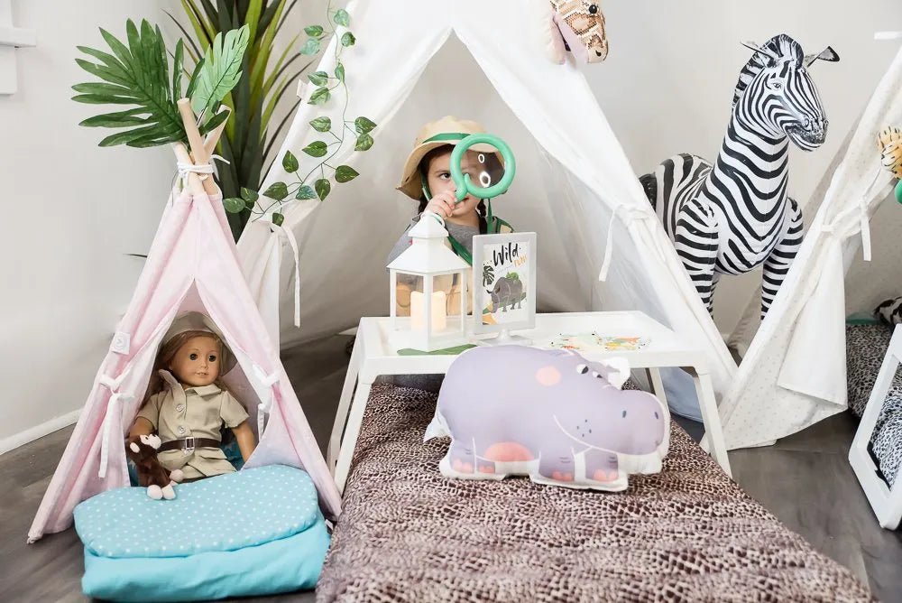A child playing in a safari themed room with a sleep tent and toys 