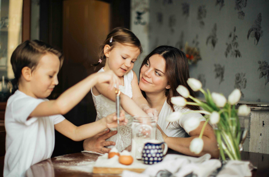 a mother baking with her two children