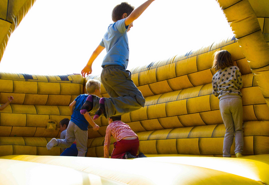 three kids jumping in a bounce house