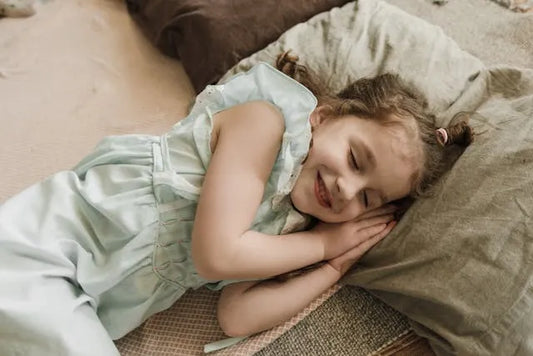 Child happily sleeping after implementing sleep routine tips. 