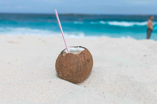 coconut with a straw on the beach