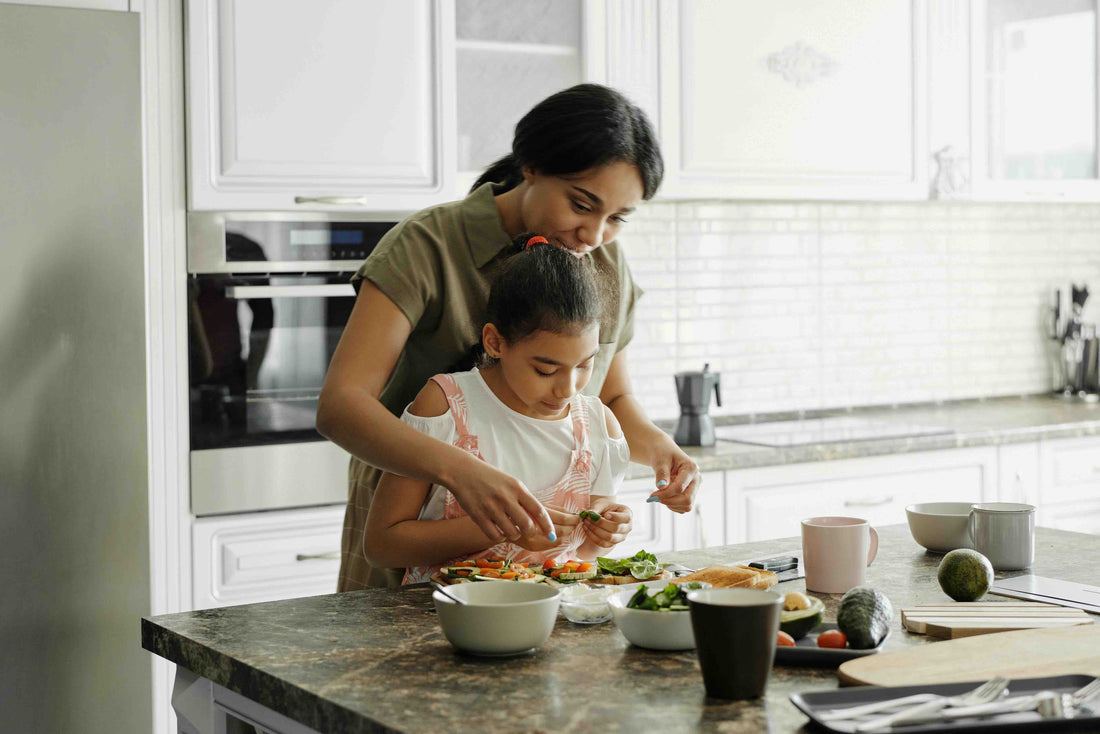 Woman helping her daughter cook 