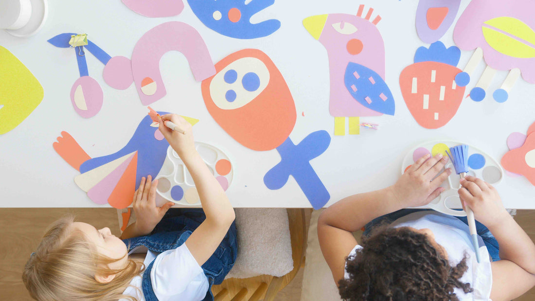 two kids working on a painting together