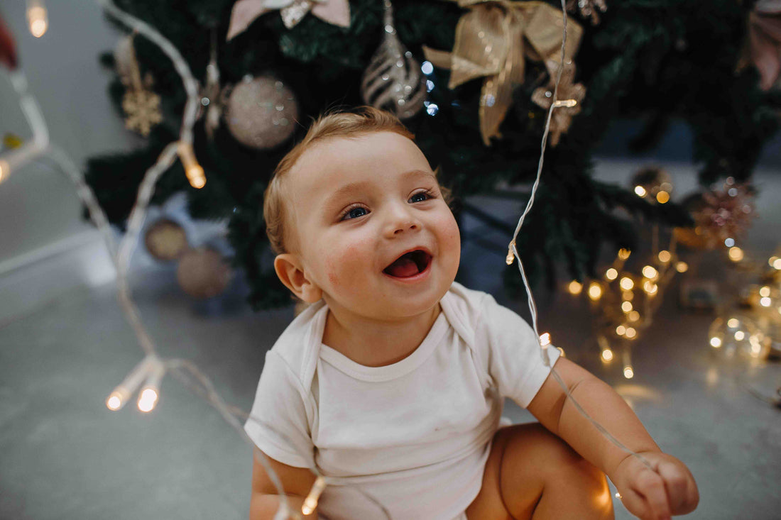 baby playing near Christmas lights