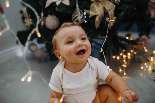 baby playing near Christmas lights