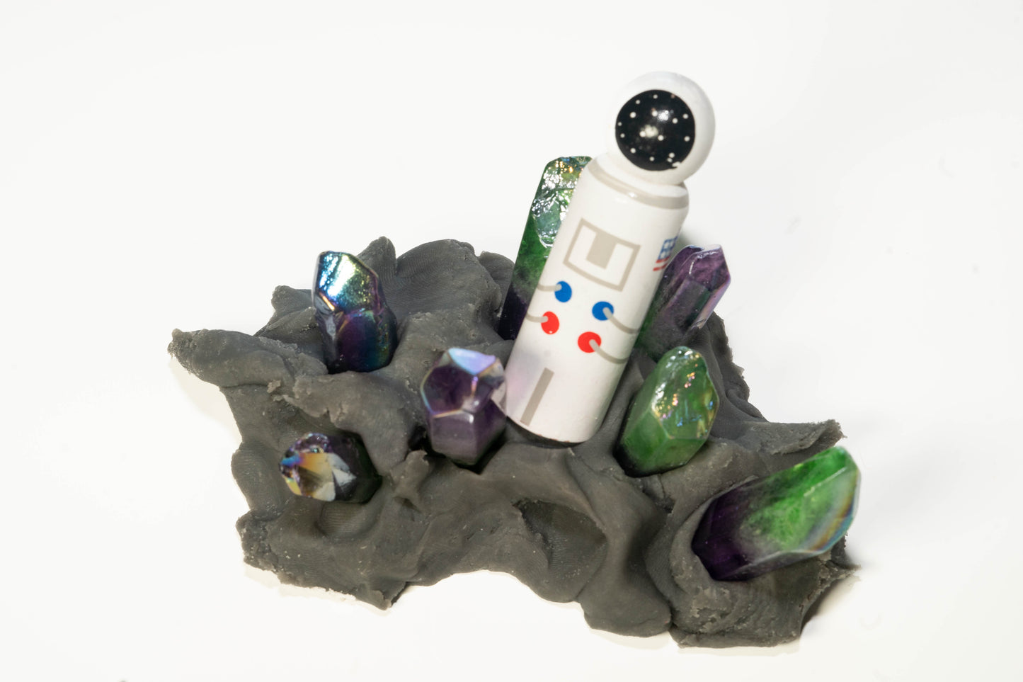 Wooden hand painted astronaut peg doll with black dough and purple and green space crystals