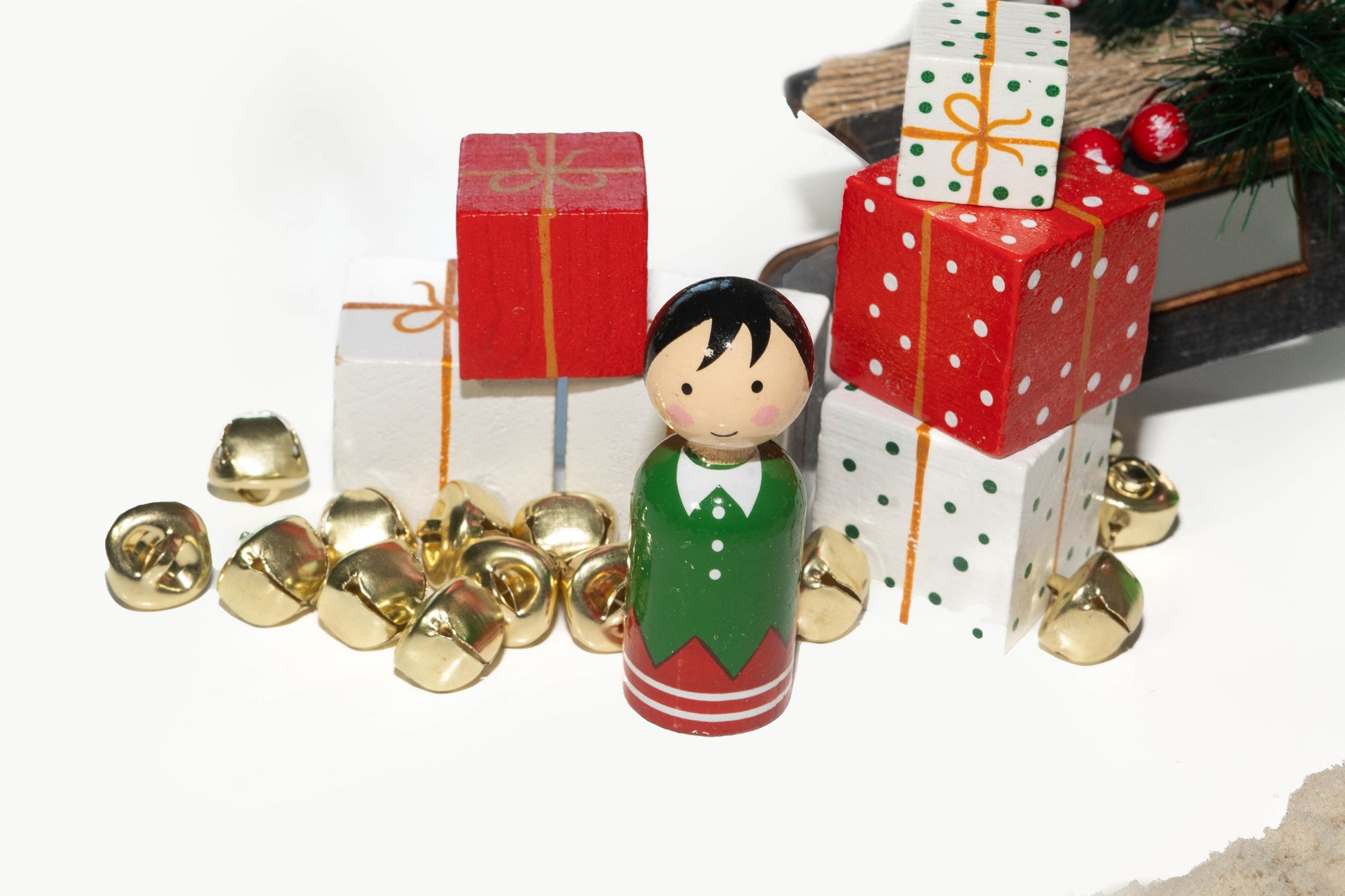 Wooden peg doll elf with gold jingle bells and red and white presents of wood blocks