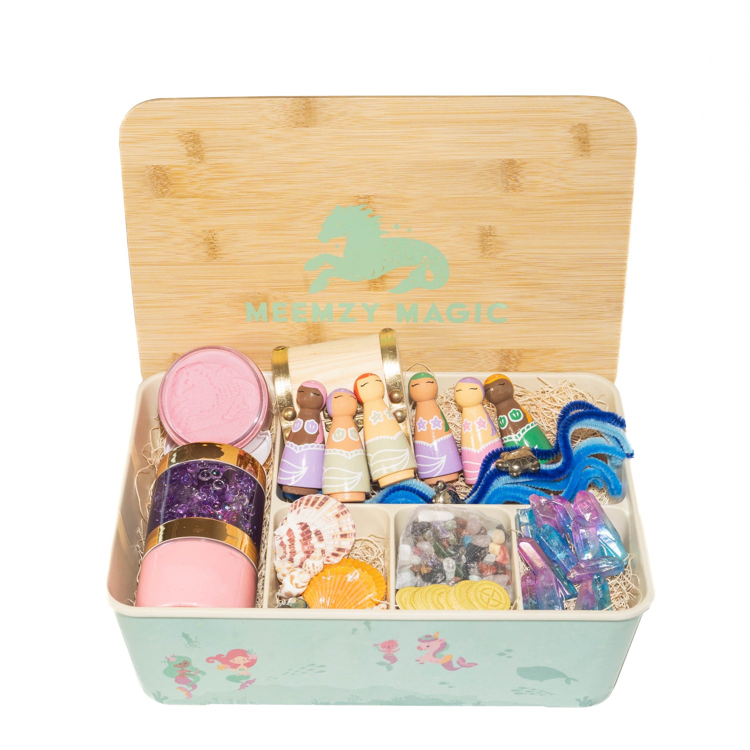 Mermaid kit contents include: purple slime, pink kinetic sand, wooden treasure chest, wildflower seed paper treasure coins, real sea shells, rainbow colors stones, shades of blue pipe cleaners, and wooden peg doll mermaids hand painted