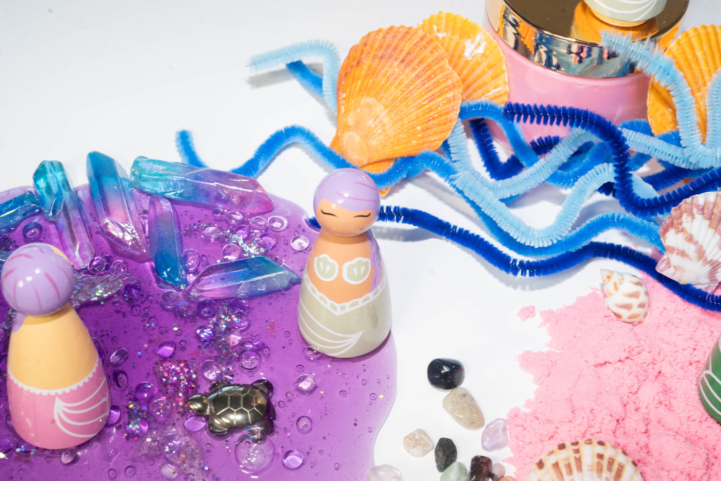 Purple mermaid peg doll hand painted, mint green tail and matching sea shell top, set in purple slime, pink kinetic sand, real sea shells, and blue pipe cleaner scene