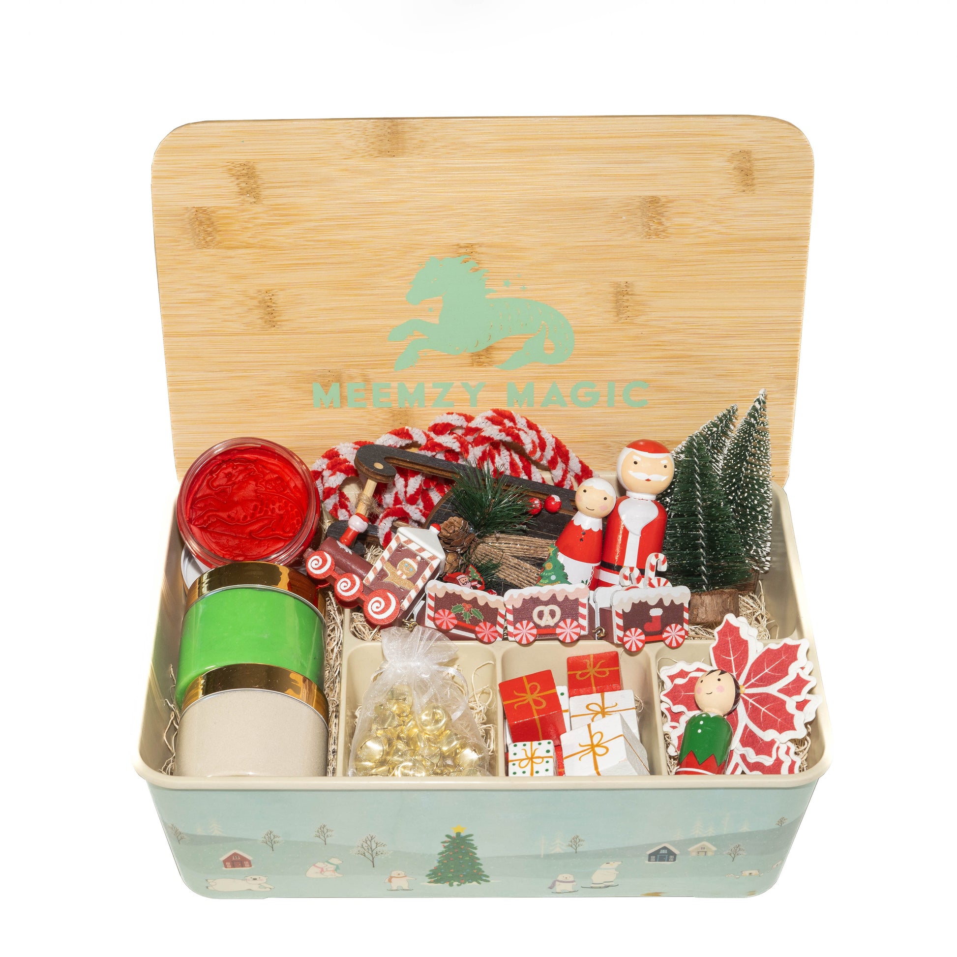 Santa Christmas sensory kit overhead shot showing contents: Santa Claus, Mrs. Claus, bottle brush Christmas trees, elf peg doll, red and green dough, white kinetic sand, jingle bells, wooden blocks for presents and wooden North Pole express train