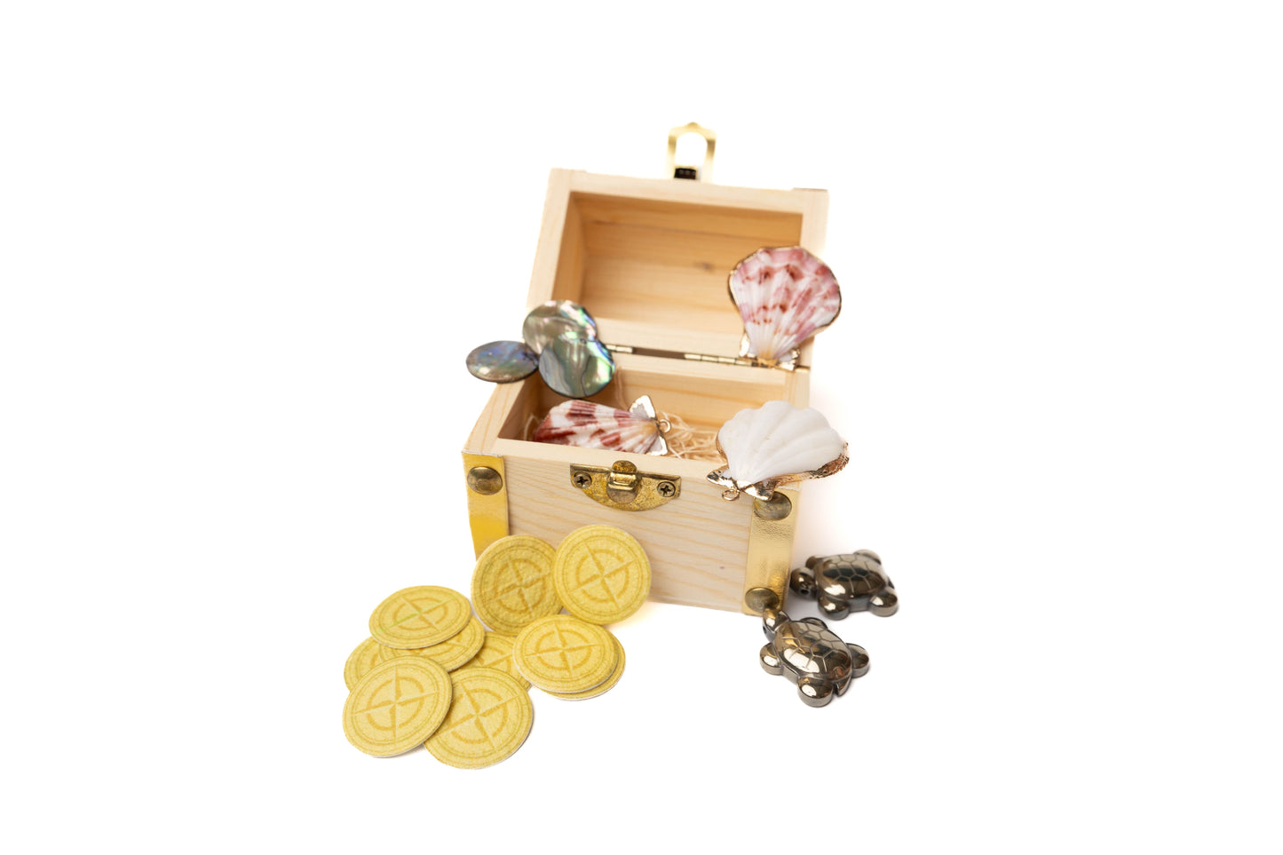 Wooden treasure chest open with contents including pyrite sea turtles, seed paper coins, sea shells lined with gold, and abalone coines