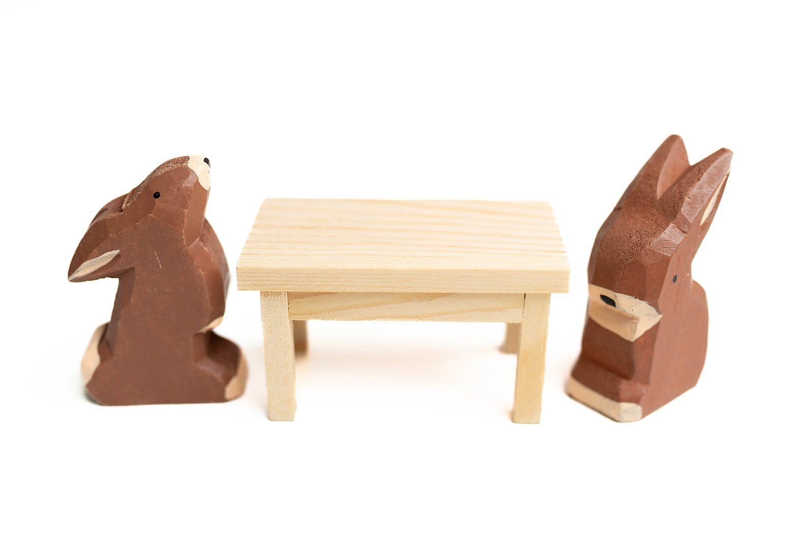 2 chocolate bunnies sitting at mini picnic table